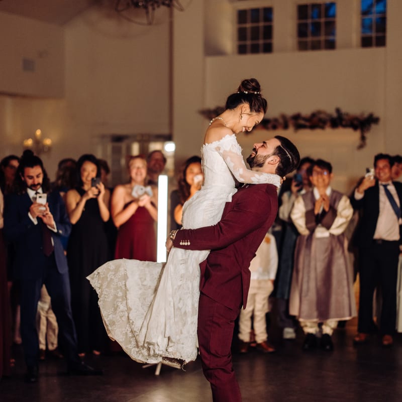Groom lifting bride during first dance
